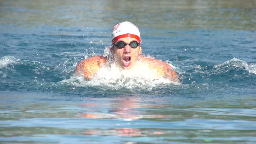 slow motion of butterfly swimmer with usa cap in swimming pool outdoors