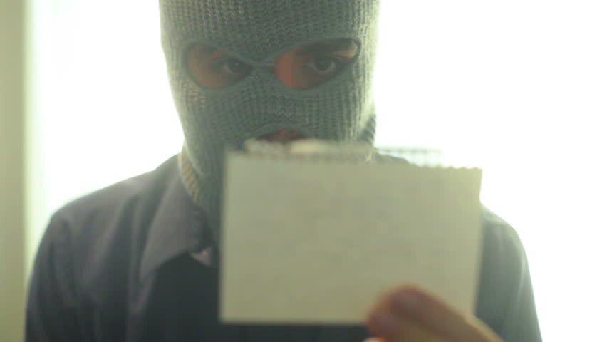 criminal reading a note.
Ransom