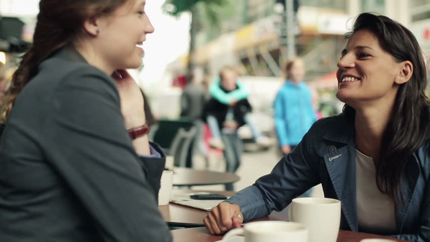 Two businesswomen talking in the cafe, steadycam shot
