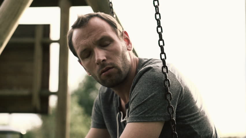 Sad, depressed man sitting on the swing, slow motion shot at 240fps
