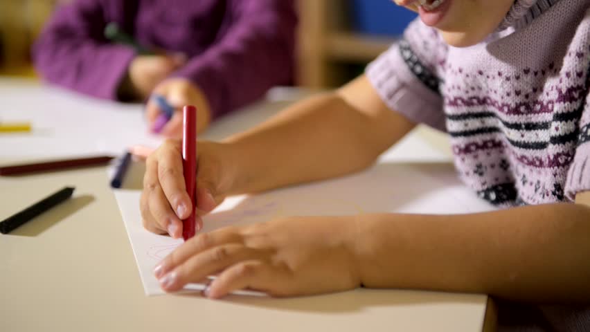 Two happy young girls drawing in kindergarten. Sequence