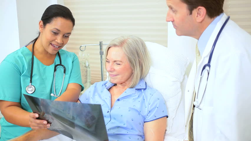 Hospital radiology staff discussing x-ray results older female patient