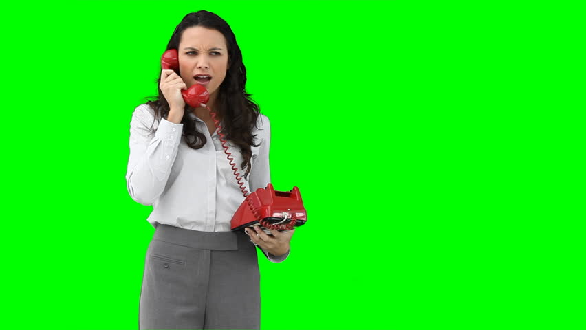 A woman on the phone talking aggressively against a green background
