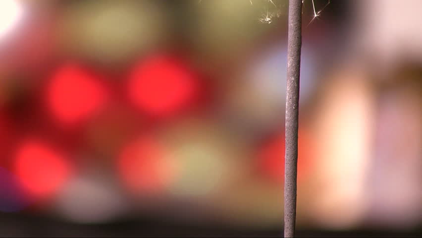 HD sparkler burning on multicolored defocused background
