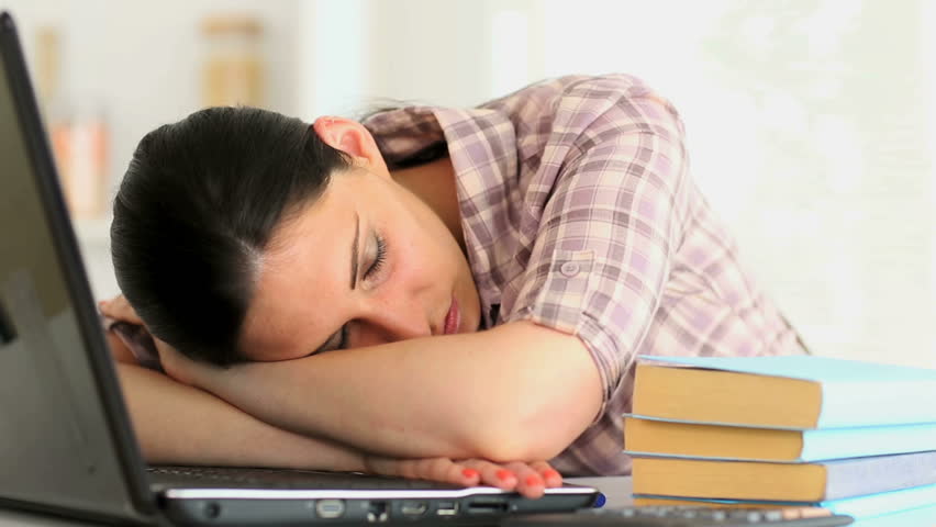 Woman napping in front of laptop at home