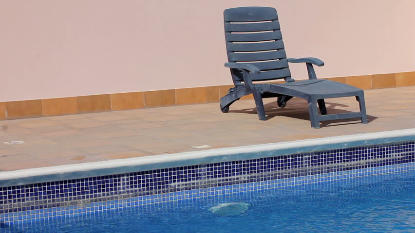empty sunbed at swimming pool