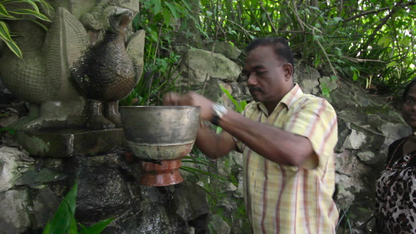 PHNOM PENH - JUNE 2012: Indians wash hair with holy water