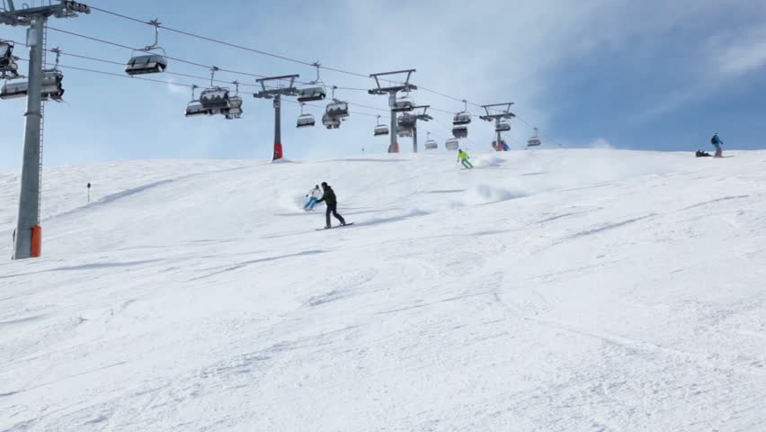 People ride ski near cableway on Austrian Alps at winter day