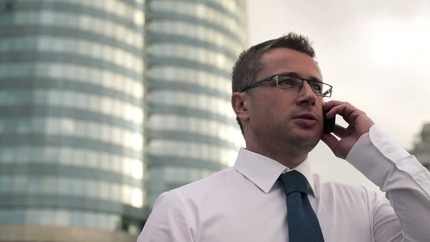 Young handsome businessman talking on mobile phone in the city
