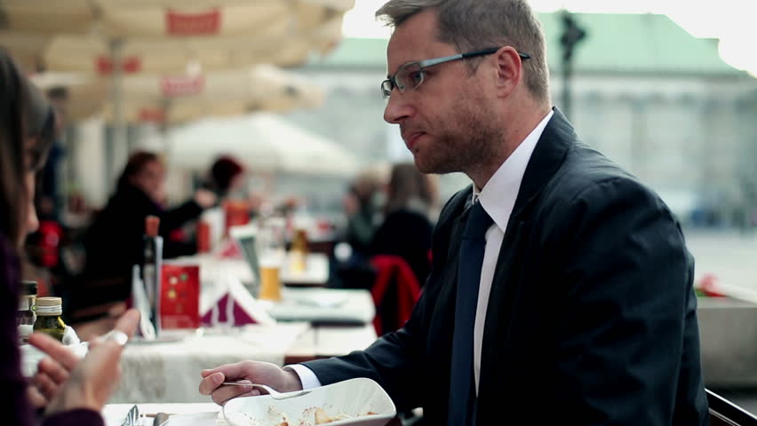 Business people with cellphone eating dinner in the restaurant, outdoor
