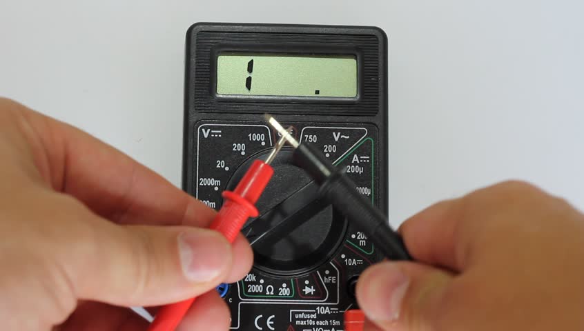 Man measures digital multimeter 