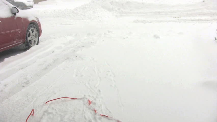 timelaspe of woman snowblowing deiveway with electric shovel