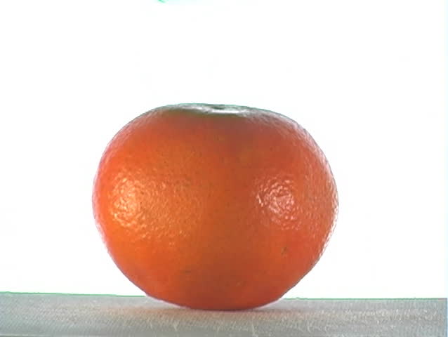 Green syrup pours over an orange.  The syrup could be apple flavor, mint flavor, or ???