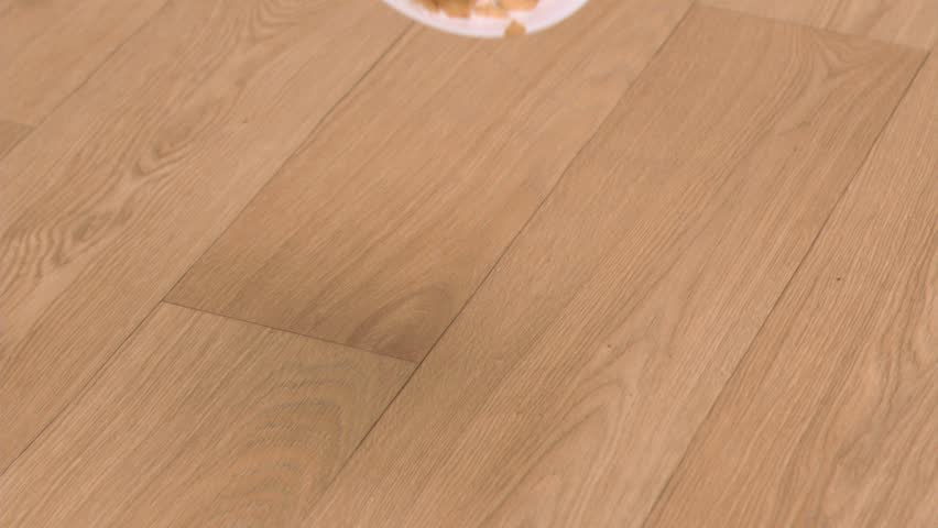 Cereals bowl falling in super slow motion on a wooden floor