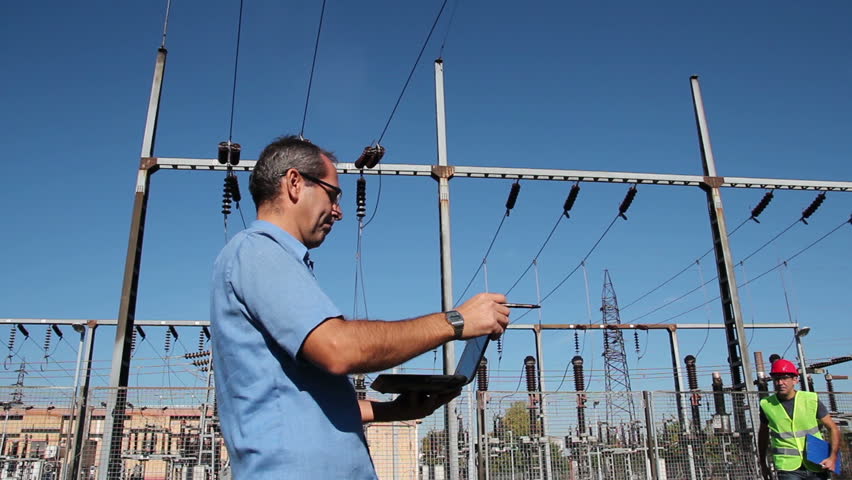 Engineer and Worker at Electrical Substation.
Smiling workers with blueprints and clipboard in meeting at electrical substation. HD1080p. 