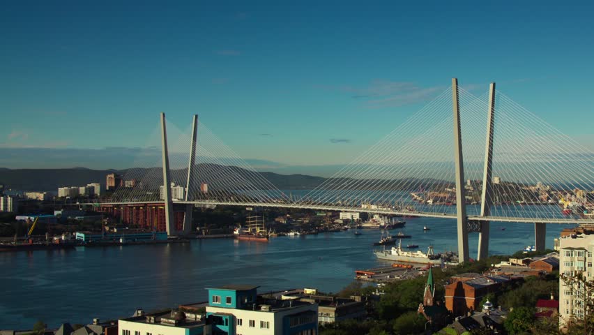 VLADIVOSTOK, PRIMORSKIY REGION/RUSSIA â 2012 SEPTEMBER 26:Timelapse - Cars move across The Golden Horn bridge, sea ships pass under. Clouds move in the sky, cranes move on the shore.