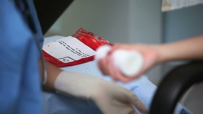 Nurse looking after a blood donor in hospital ward