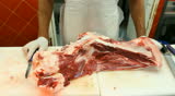Butcher shop Butcher man hand cutting raw meat with meat chopper. 