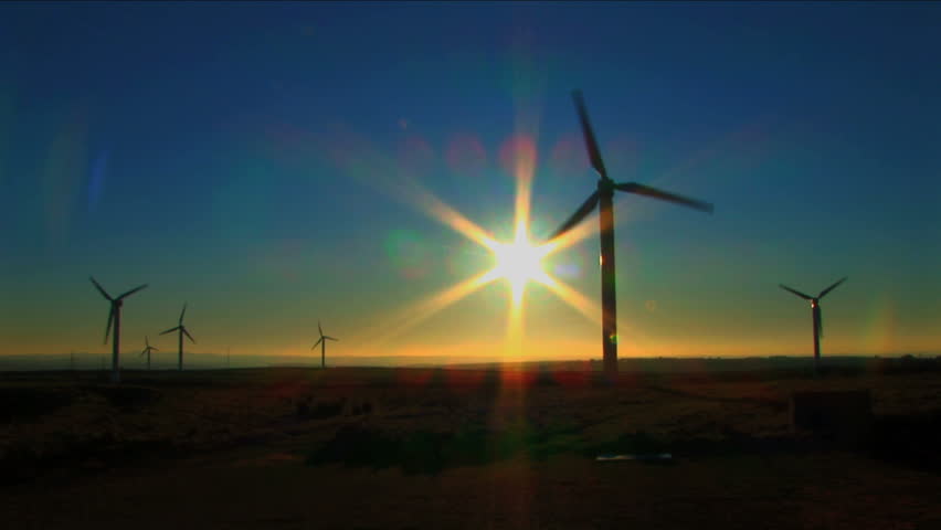 Wind turbine against a blue sky at sunset