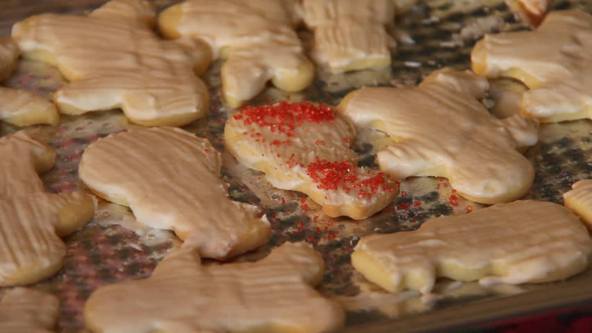 Baking Sugar Cookies 20. Preparing, mixing, baking and decorating Christmas sugar cookies. Decorating the iced cookies with seasonal sprinkles.
