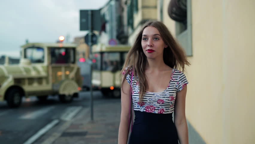 Beautiful young woman walking alone in night city
