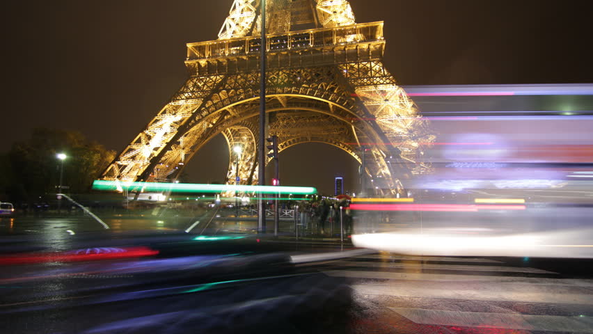 PARIS, FRANCE â APRIL 8th: Timelapse of Eiffel tower on rainy night on April 8th, 2012. Tourists and traffic passing by. Some raindrops on lens heighten the mood.