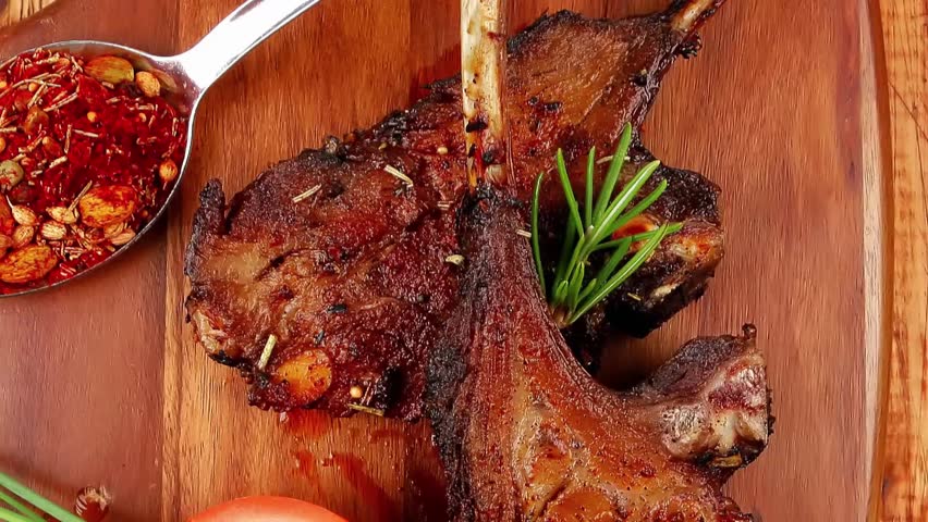 savory plate on wood : grilled ribs on plate with chives and tomato isolated on wooden table