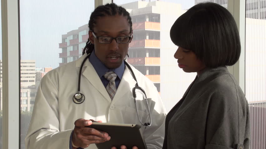 Doctor discussing results with patient on tablet