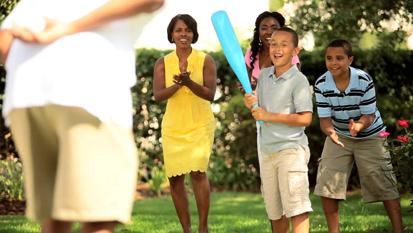 Healthy diverse family playing baseball outdoors