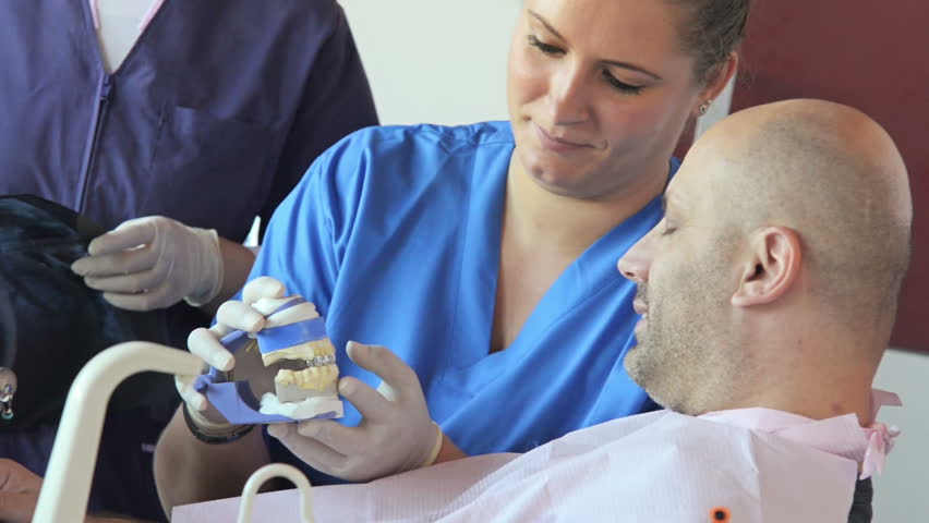 Close-up of patient receiving details from his dentist about dental molds
