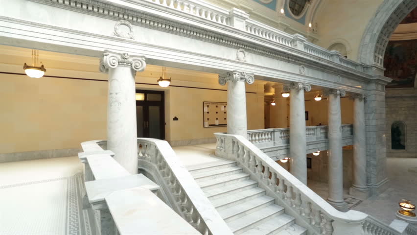 Utah State Capital pan balcony stairs across rotunda floor. Capitol building high on a hill overlooking the city of Salt Lake City. Elegant architectural interior design of marble and copper dome.