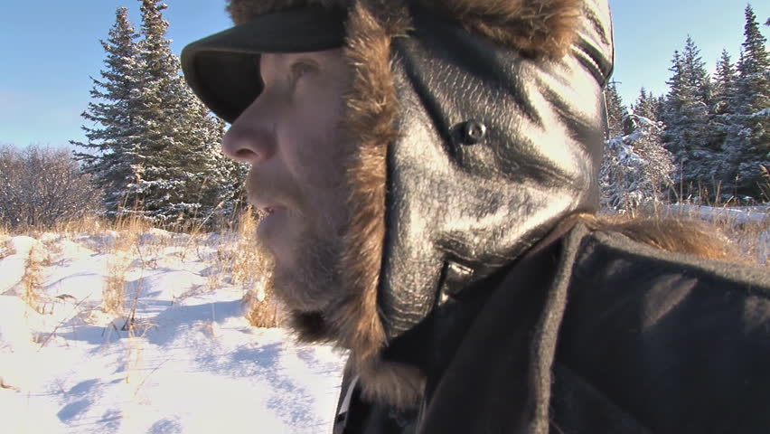 Suited up for the cold, a man walks through snowy country. Alaska that is. With a Glidecam.