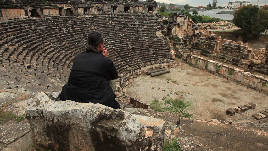 Man sitting on the stone chair in ancient amphitheater Myra