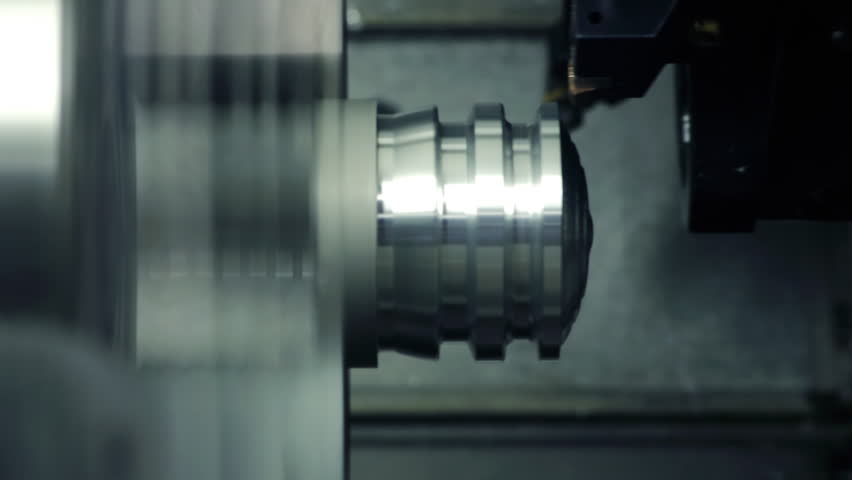 CNC milling machine makes some steel part on a factory