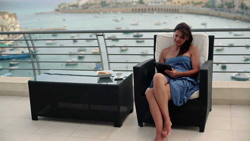 Young woman chatting on tablet computer on terrace
