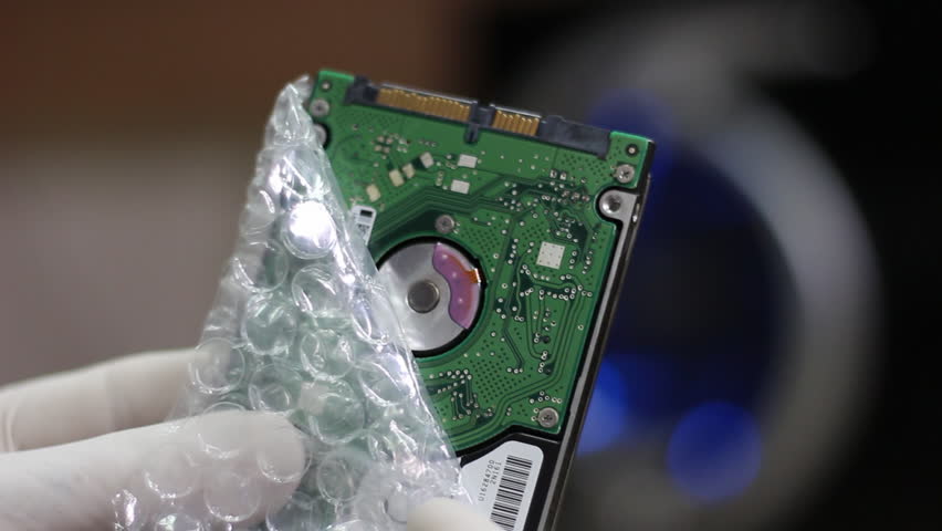 Technician wrapping hard drives for shipment    