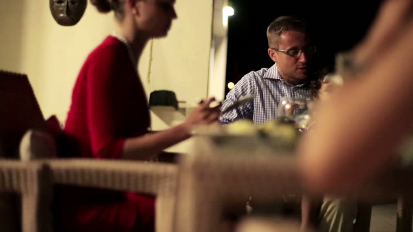 Family with friends eating dinner in the evening, stabilized shot