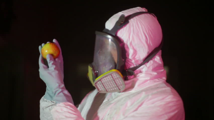 hazmat scientist looking at an apple
