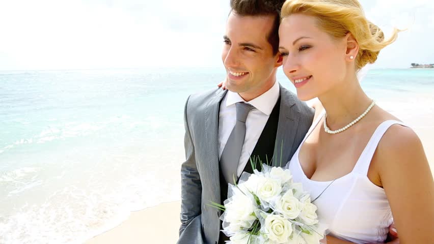 Bride and groom walking on a sandy beach