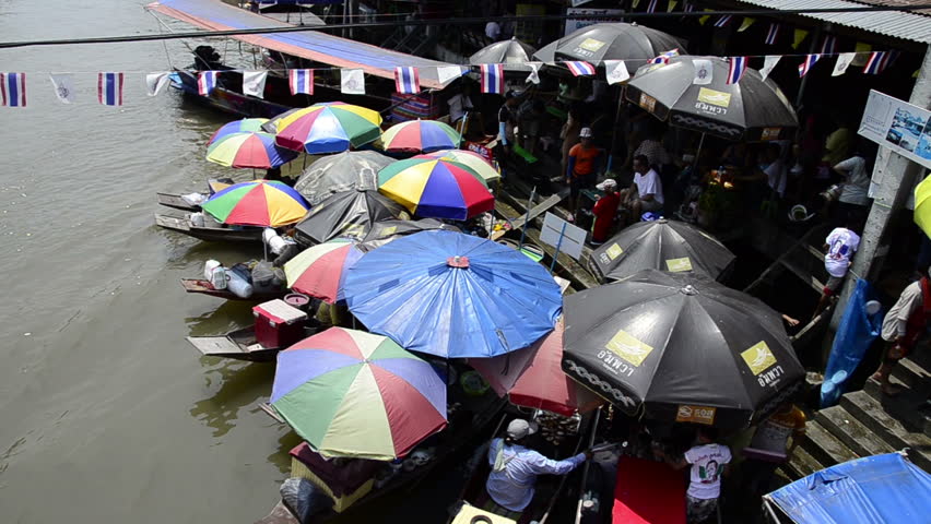 AMPHAWA, THAILAND - CIRCA Mar 2012: Amphawa Floating Market, busy waterfront market where vendors sell their goods from traditional longboats.