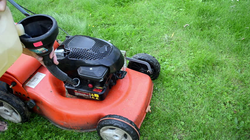 man hand refill fill empty orange grass lawn mower cutter fuel tank.