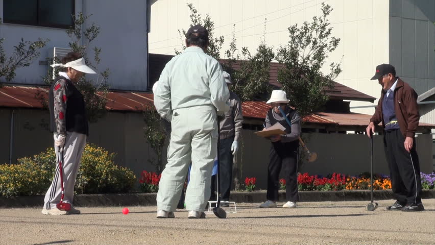 TAKAYAMA, JAPAN - 19 OCTOBER 2012: Senior citizens are playing a game of 'gateball', a popular pastime among the elderly in Japan