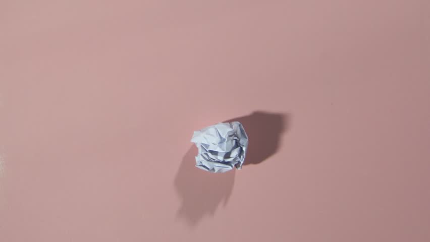 hd video of blank white paper unwrapping/paper ball unwrapping/blank white paper ball unwrapping on pink background