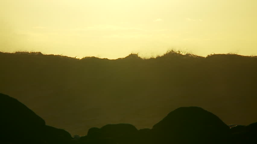 HAWAII, USA, 2012 Large waves as they crest and break in slow motion at sunset.