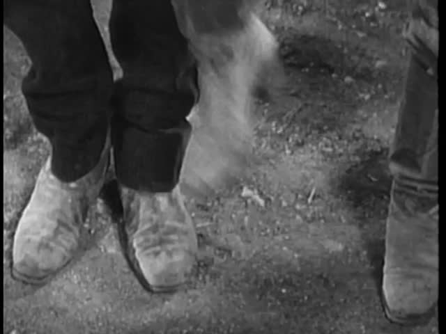 Low angle view of cowboy stomping on man's foot