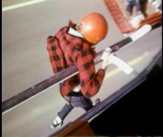Stunt man hanging on helicopter above country road
