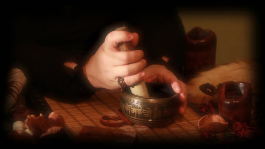 hands preparing a potion ,love potion, old recipe, mixing powders and stones in magic bowl. Closeup . Soft blur