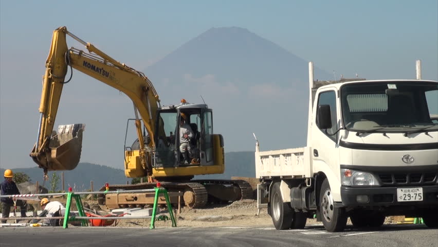 HAKONE, JAPAN - 16 OCTOBER 2012: Construction work on a road is proceeding with the magnificent Mount Fuji in the background, providing for an interesting contrast, in Hakone, Japan