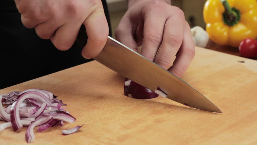 Chef cutting up an onion with a knife
