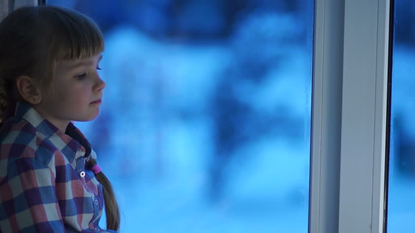 Child dreaming to walk on the playground in winter. Snow falls on the street
